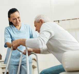 caregiver helping senior to stand
