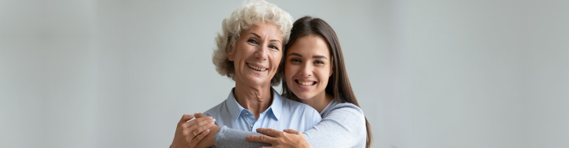 female caregiver hugging senior woman
